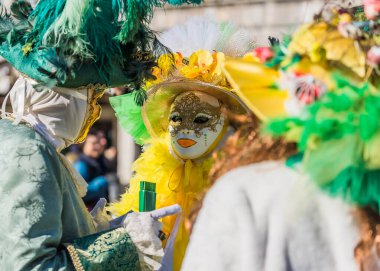 People wearing elaborate and colorful costumes and masks during the Venice 2023 carnival in Venice, Italy