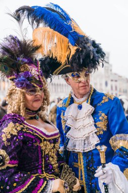 People wearing elaborate and colorful masks and costumes during the Venice carnival in Italy