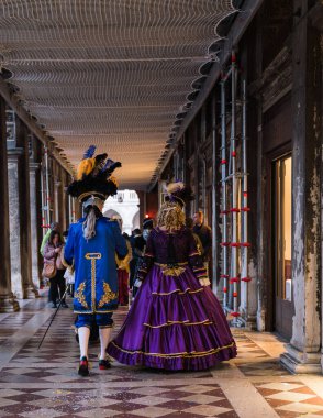 People wearing elaborate and colorful masks and costumes during the Venice carnival in Italy