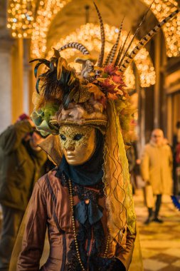 People wearing elaborate and colorful masks and costumes during the Venice carnival in Italy