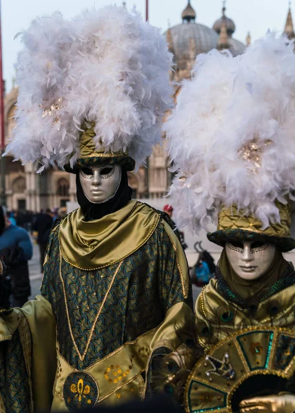 People wearing elaborate and colorful masks and costumes during the Venice carnival in Italy