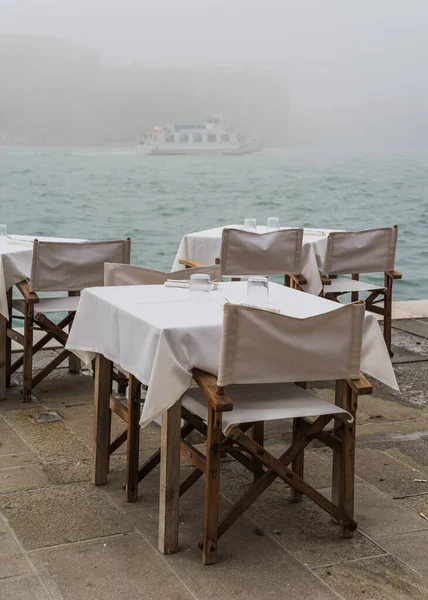 stock image Outdoor restaurant tables in Venice, Italy during a foggy day