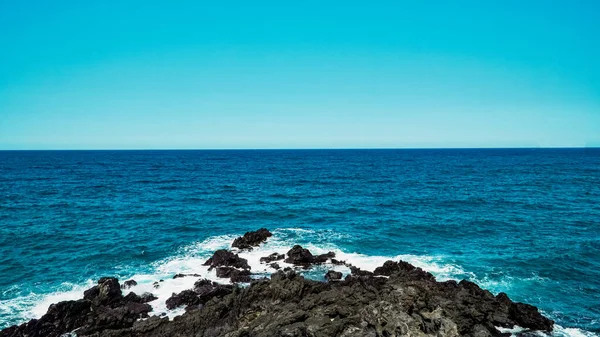 Blauwe Lucht Zomerzee Met Rotsachtig Golfschuim — Stockfoto