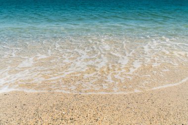 Yaz kumsalı kumu, mavi dalgalar ve beyaz köpük