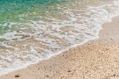 Yaz kumsalı kumu, mavi dalgalar ve beyaz köpük