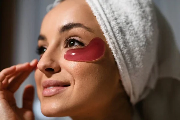 Close up shot of gel eye patches on female face. Beautiful Caucasian woman applied eye patches on face. Skincare product concept. Home beauty treatment. Cosmetics and beauty concept