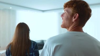 Close up of Caucasian happy young married couple entering the apartment and hugging feeling happy. Cheerful man and woman in new home. Couple has bought new house. Marriage, mortgage concept. Real