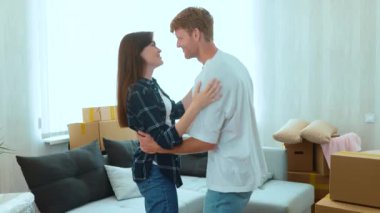 Happy young family couple dancing in good mood in new home on the moving day. Caucasian joyful wife and husband dance in new apartment with boxes. Relocation. Spouses buy own house. Close up concept