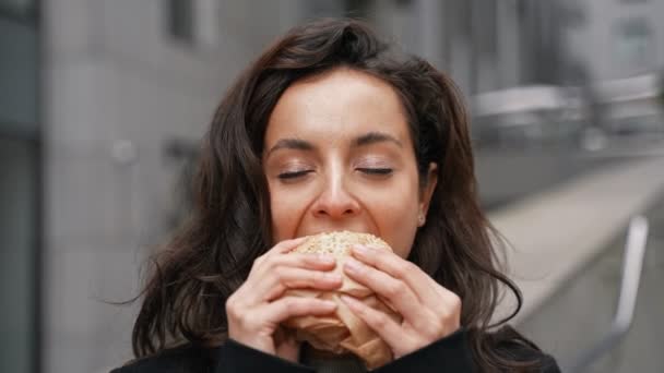 Menina Bonito Olhando Para Câmera Comer Delicioso Hambúrguer Com Prazer — Vídeo de Stock