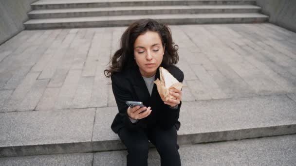 Junge Hübsche Frau Sitzt Auf Der Treppe Isst Leckeres Sandwich — Stockvideo