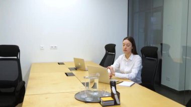 Beyaz kadın ahşap masadaki beyaz ofiste oturuyor, erkek odaya giriyor, oturuyor ve kadına kağıt veriyor. Erkek, iş görüşmesi için büyük şirkete geldi. Gergin görünüyor..