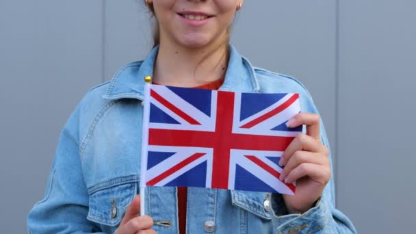 Vit Tonårstjej Röd Shirt Och Denimjacka Som Håller Storbritanniens Flagga — Stockvideo