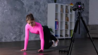 Sportif kadın evde kalas egzersizi yapıyor. Genç bayan telefon ekranına dokunarak spor minderi kullanarak kas çalıştırıyor. Spor, spor, aerobik, sağlık konsepti