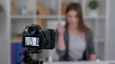 Gülümseyen kadın vlogger evde oturup takipçilere para gösterirken video kaydediyor. Yavaş çekim videosu. İş konsepti