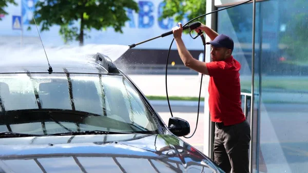Young Caucasian Male Worker Washing Car Holding Hand Hose High — Stockfoto