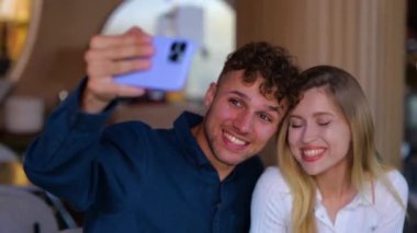 Sevgi dolu bir çift kafede selfie çekiyor. Mutlu adam ve kadın çıkarken yemek yiyorlar. Erkek cep telefonu. Aşk, flört, yemek, yaşam tarzı konsepti. Gerçek zamanlı.