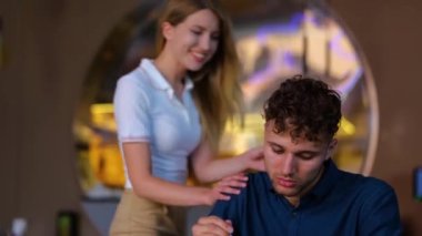 Kafedeki erkek arkadaşının gözlerini kapatan mutlu kadın. Kadın, erkeğe sürpriz yapmış. Aşk, flört, yemek, yaşam tarzı konsepti. Gerçek zamanlı.