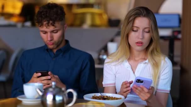 남자와 여자가 휴대폰을 다투고 있습니다 카페에 문자를 입력하고 관계에 문제가 — 비디오