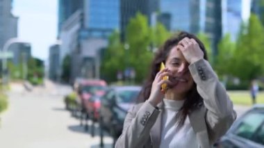Büyük bir şehirde gülümseyen başarılı iş kadını akıllı telefondan konuşuyor. Uzayı kopyala İş, teknoloji kavramı. Gerçek zamanlı.