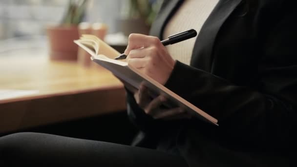 Genç Güzel Bir Bayan Kafeteryada Oturuyor Elinde Kalem Kağıda Alıyor — Stok video