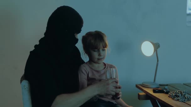 男绑匪给人质事件中的小女孩倒杯水强盗和地下室里的孩子复制空间 绑架儿童的概念 慢动作 — 图库视频影像