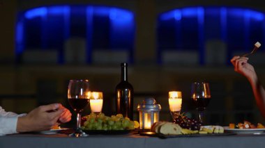 Kameralar, akşam yemeğinde dışarıda mumlarla süslenmiş masada oturan beyaz, zarif çiftten geri çekiliyor. Yıldönümü kutlaması. Ağır çekim. Romantik bir akşam yemeği. Aşk konsepti