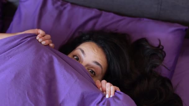Игривая Красотка Прячущая Лицо Подглядывающая Одеяла Лежащая Мягкой Подушке Постели — стоковое видео