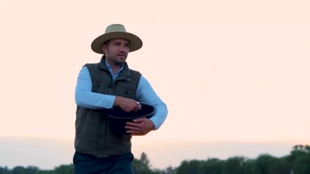 農業分野でそれを投げながら幸せな男性農家の種子穀物 種子事業 生態学の概念 リアルタイム — ストック動画