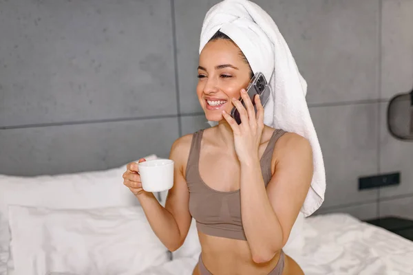 Glad Dam Underkläder Håller Kopp Kaffe Medan Talar Smartphone Sovrummet — Stockfoto