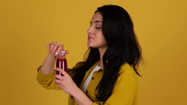 Zadowolona Kobieta Gasząca Pragnienie Pijąca Sok Butelki Odizolowana Żółtym Tle — Wideo stockowe