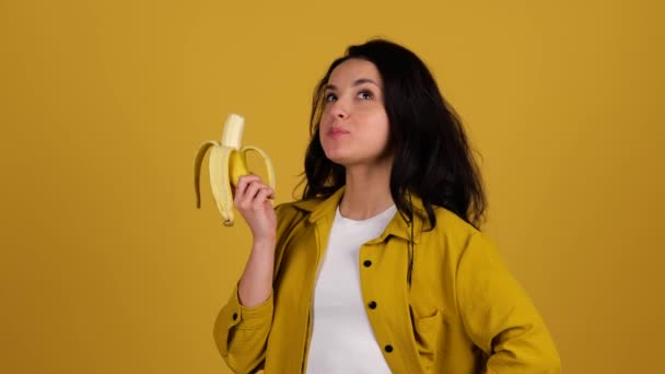 Glad Söt Dam Stående Medan Håller Banan Äter Den Isolerad — Stockvideo