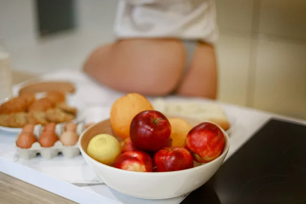 Close Van Een Kom Fruit Keukentafel Vrouwelijke Billen Wazige Achtergrond — Stockfoto