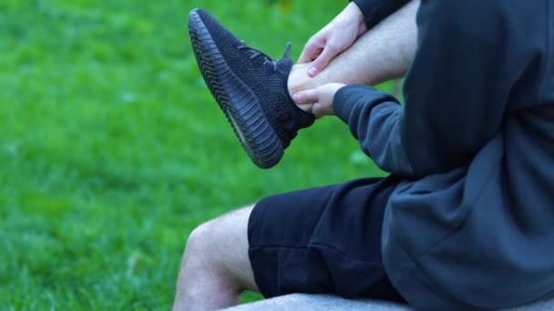 Sportler Schwarzen Shorts Kapuzenpulli Turnschuhen Entspannt Sich Massiert Sein Bein — Stockvideo
