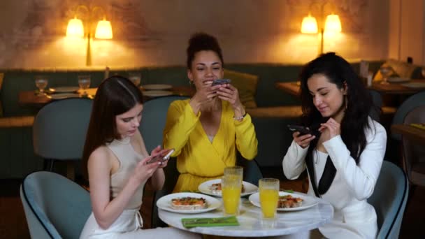 Amigas Haciendo Fotos Comida Mientras Usan Teléfonos Móviles Cenando Restaurante — Vídeos de Stock