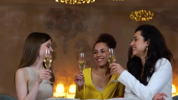 Trzy Młode Kobiety Dzwoniące Kieliszkami Szampana Podczas Kolacji Nowoczesnej Restauracji — Wideo stockowe