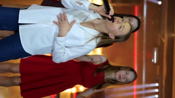 笑顔の若い女性がマイクと歌を歌っている ナイトクラブでカラオケを楽しむ女性たち ライフスタイル パーティー ディスコ ソーシャルネットワークのコンセプト スローモーション — ストック動画