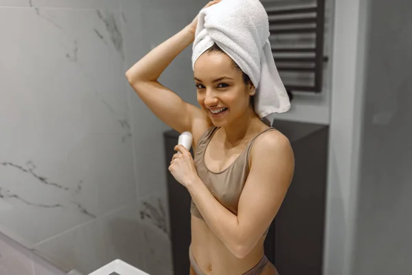 Uśmiechnięta Piękność Ręcznikiem Głowie Stojąca Łazience Używająca Kosmetyku Rutynowa Samodzielna — Zdjęcie stockowe