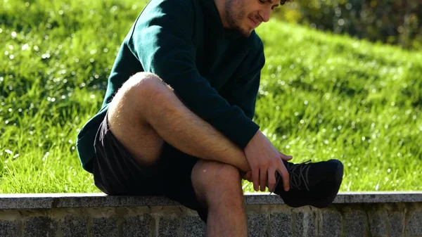 Sportovec Outdoorových Aktivitách Protáhne Nohu Lavičce Zeleném Parku Zblízka Muž — Stock fotografie