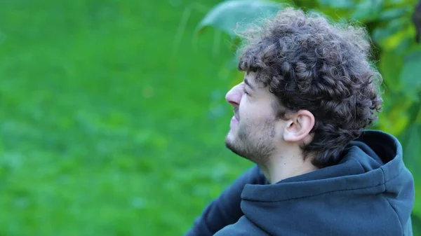 Молодой Кавказский Мужчина Массирует Ногу Зеленом Парке Сидя Бетонной Скамейке — стоковое фото