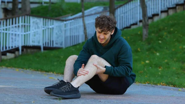 Young Caucasian Man Sitting Ground Stretching His Knee Leg Muscles — Stock Photo, Image