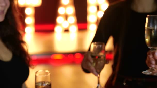 女性的手举着香槟酒祝酒 站在夜总会里 生活方式 迪斯科的概念 慢动作 — 图库视频影像