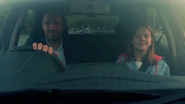 Sevimli genç kız babasıyla şehirde arabada vakit geçiriyor. Sağ el sürücüsü araba. Yaşam tarzı, aile, seyahat, ebeveynlik kavramı. Gerçek zamanlı.