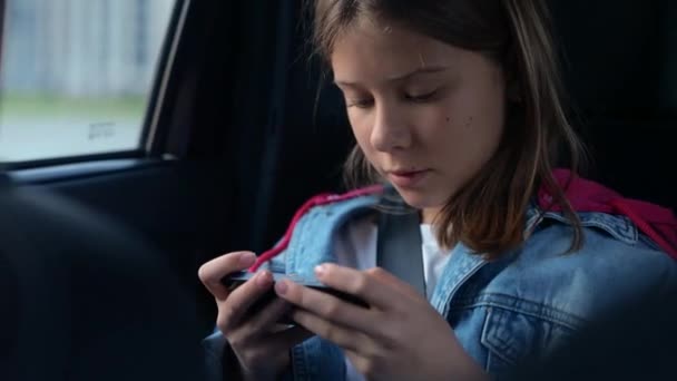 Female Teen Sitting Back Seat Car While Holding Mobile Phone — Stock Video
