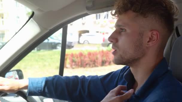 運転中に車の中に座っている若い男性の運転手は 暑いと感じています 右ハンドドライブカー ライフスタイル 輸送コンセプト リアルタイム — ストック動画