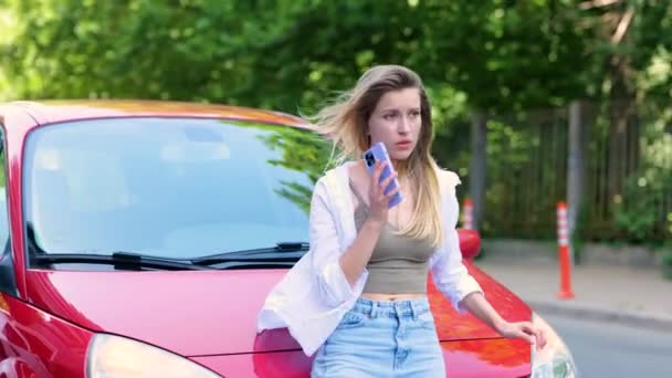 Dışarıda Arabasının Kaputuna Yaslanırken Cep Telefonuyla Konuşan Heyecanlı Bir Kadın — Stok video
