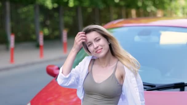 Uśmiechnięta Atrakcyjna Kobieta Stojąca Obok Czerwonego Samochodu Zewnątrz Opierająca Się — Wideo stockowe
