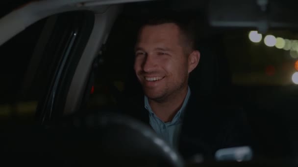 Улыбающийся Молодой Мужчина Рулем Современного Автомобиля Городе Ночью Правый Руль — стоковое видео