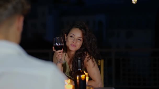 幸せな美しい女性は 座ってワインのグラスを保持しながら日付を楽しんでいます 屋上でのロマンチックなデート ロマンチックなコンセプト 恋するカップル リアルタイム — ストック動画
