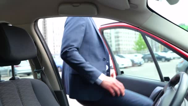 ドアを開けて車に乗るスーツの若いスタイリッシュな男 シートベルトを使用した男性 ビジネス 人々のコンセプト スローモーション — ストック動画