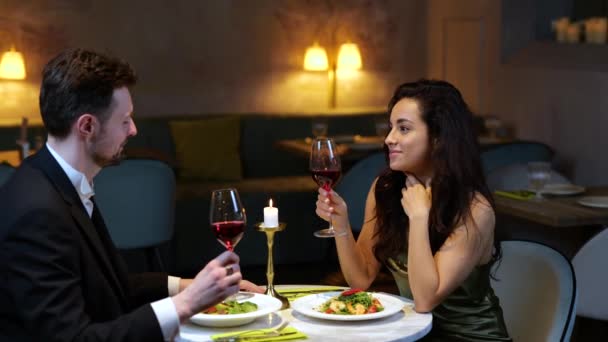 笑顔のロマンチックなカップルは レストランでデートを楽しんでいる間 ワイングラスでクライミング ライフスタイル 人間関係の概念 スローモーション — ストック動画